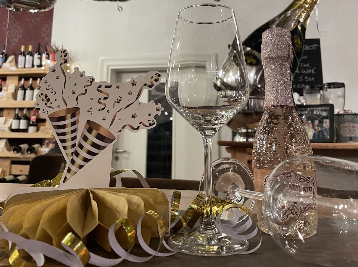 Unterschiedliche Häppchen-Spieße aus Käse, Weintrauben und Schinken sind auf Brettern angerichtet.