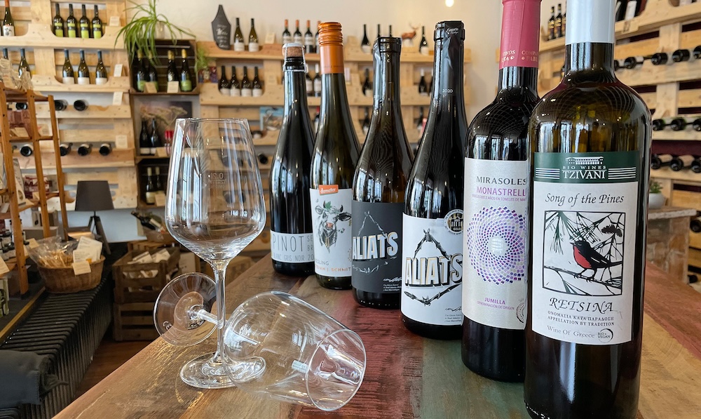 Mehrere Weinflaschen sind auf einem Tischen nebeneinander aufgereiht.