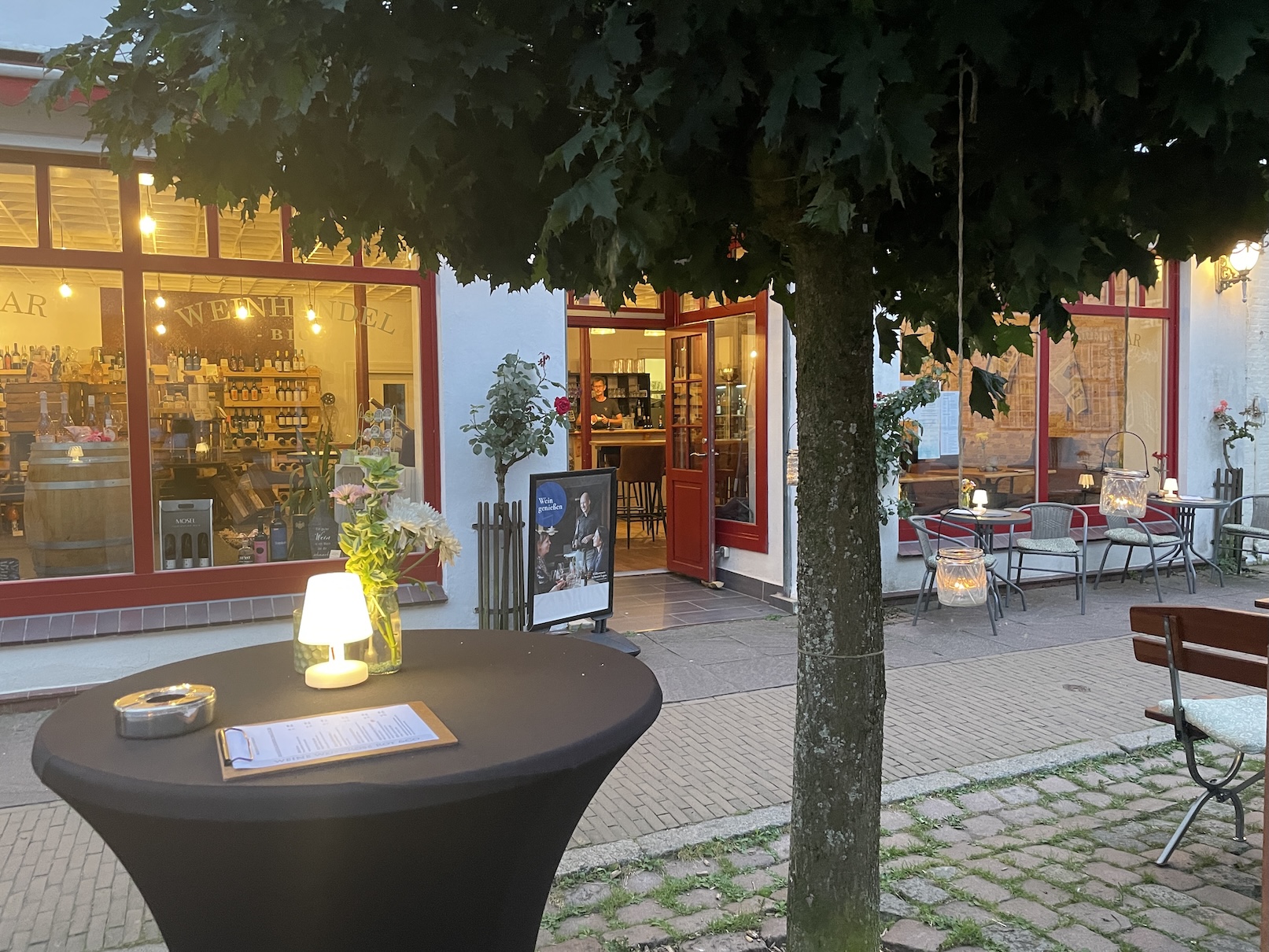 Frontansicht der Wiendruuv. Vor dem Schaufenster sind Tische und Stühle.