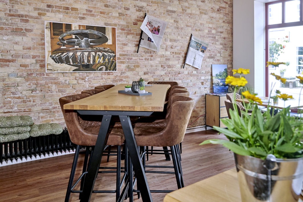 Hochtisch mit gemütlichen Barhockern mit Arm und Rückenlehne.